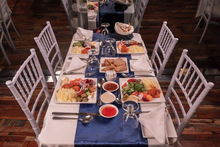 A dining table set with plates of food, silverware, and glasses. 4