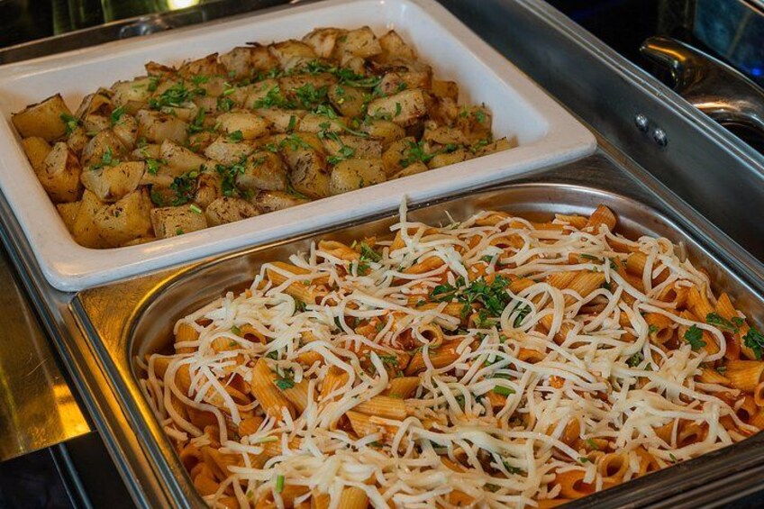 A buffet with pasta and roasted potatoes. 2