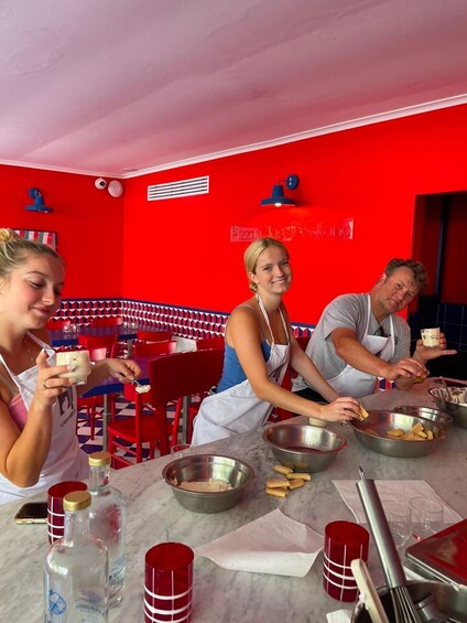 A group of people in a red-themed restaurant, preparing food. 3