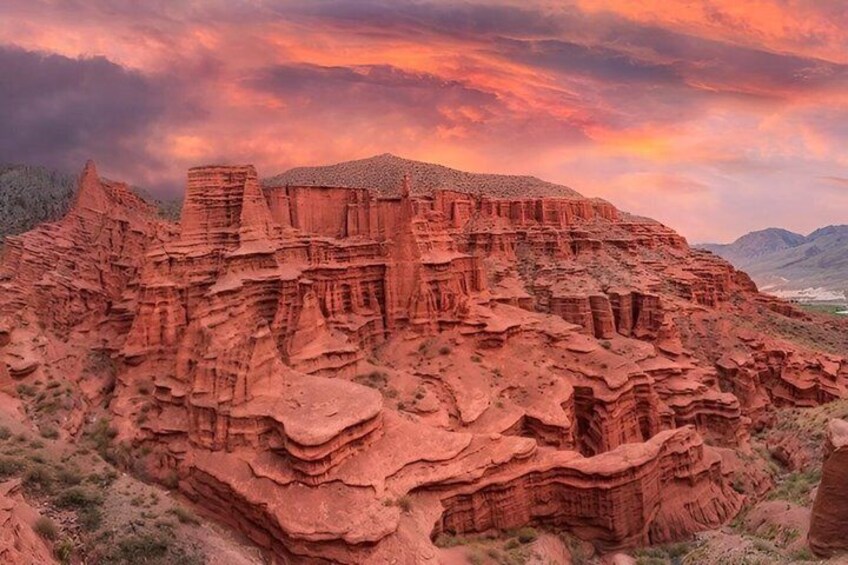 A red rock canyon with layered formations and a sunset sky. 3