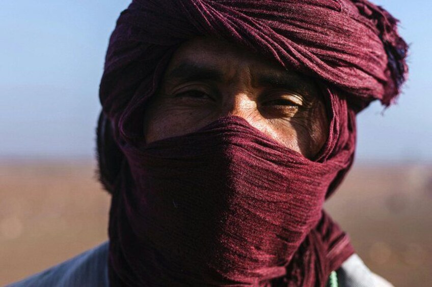 A person with a headscarf in a desert landscape. 1