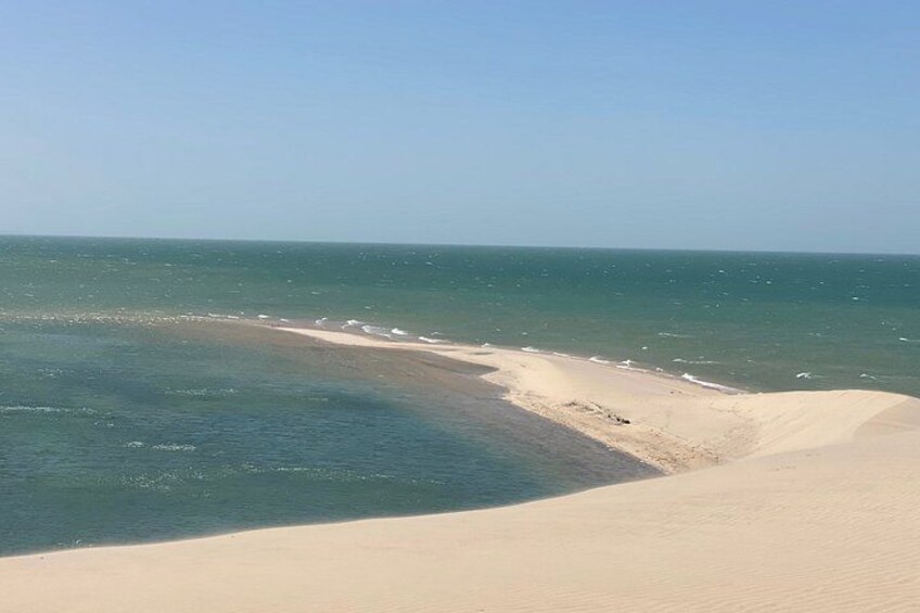A beach with sand dunes and the ocean. 2