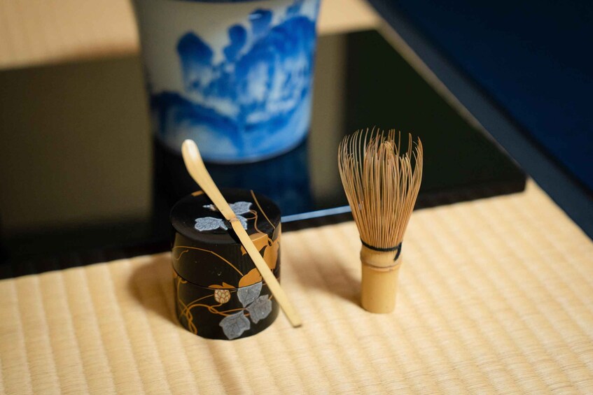 A traditional Japanese whisk and a matchstick on a tatami mat. 5