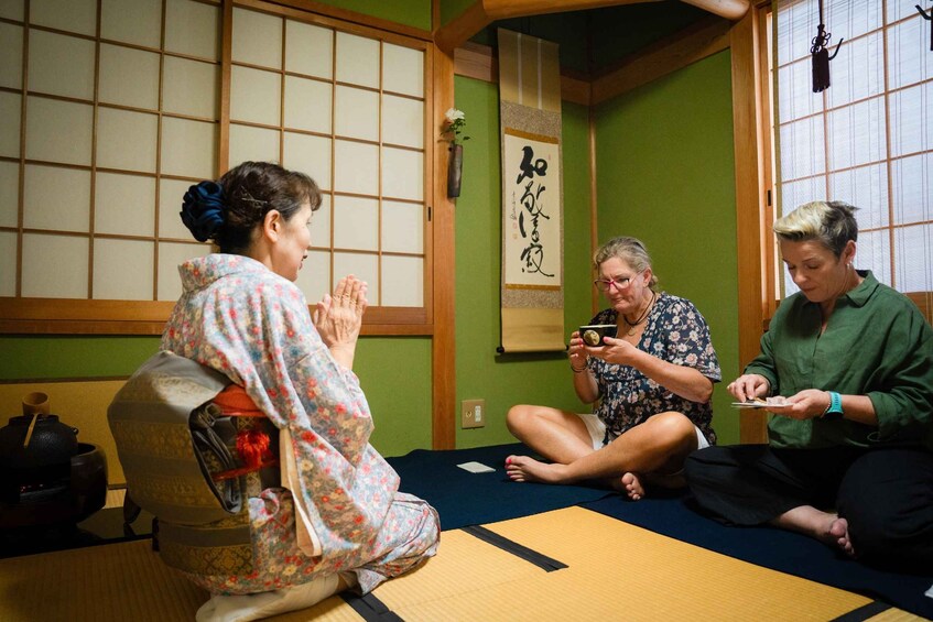 A traditional Japanese room with tatami flooring, shoji screens, and a hanging scroll. 2