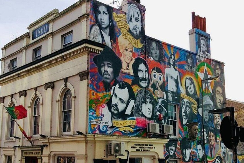 Un edificio con un mural colorido que muestra diversos estilos artísticos y figuras. 2