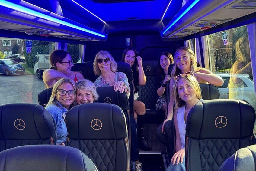 A group of people inside a vehicle with a blue interior lighting. 4