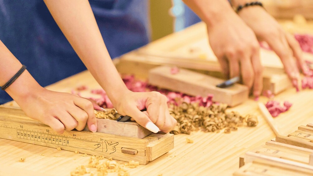 People working with wood, measuring and cutting. 2