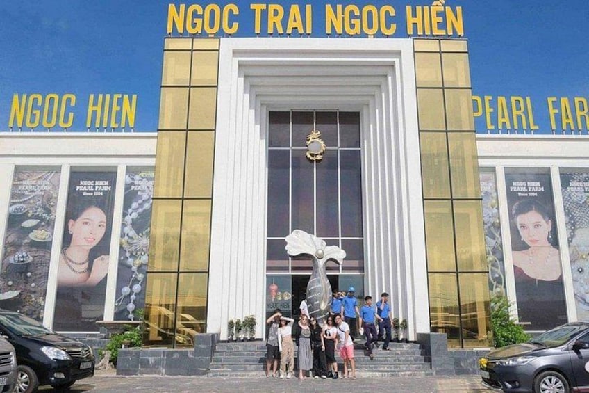 A building with large posters and the text 'NGOC TRAI NGOC HIEN' and 'PEARL FARM'. 4