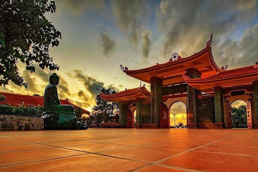 A traditional Chinese gate with a Buddha statue in front. 5