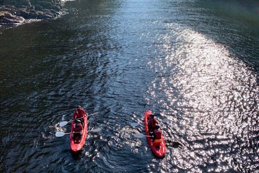 Two kayaks on a calm body of water with sunlight reflecting off the surface. 5