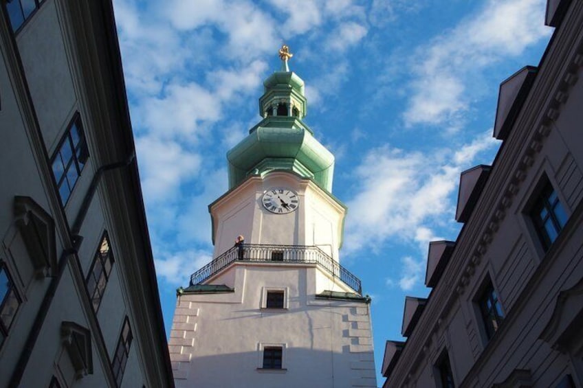 A clock tower with a green dome and a balcony. 2