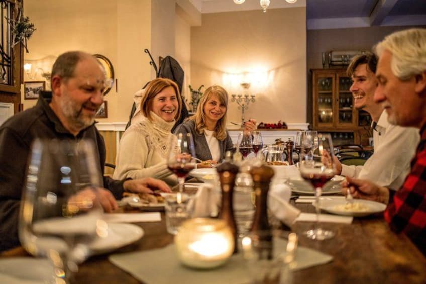 Un groupe de personnes est réuni autour d’une table, avec des verres à vin et des assiettes. 2