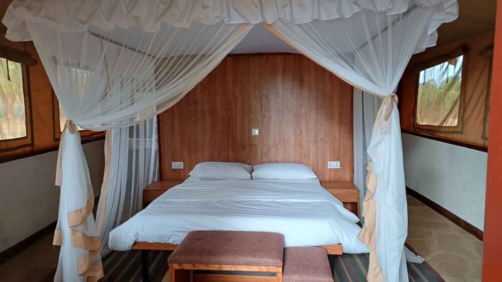 A four-poster canopy bed with white linens and a wooden headboard. 5
