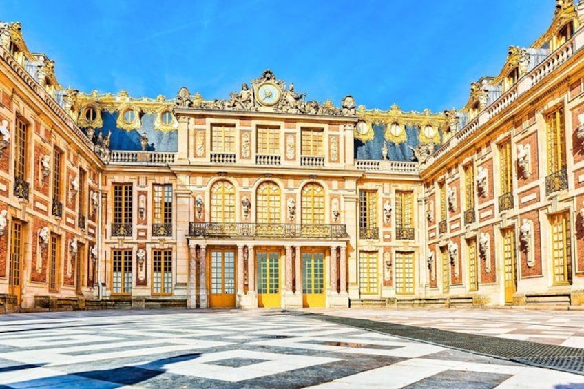 Un edificio imponente e decorato, con facciata simmetrica, ampie finestre e un ingresso centrale. 1