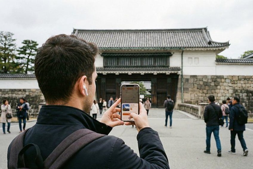 A person taking a photo of a traditional building with a tiled roof. 5