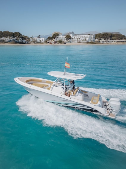 A white speedboat with a flag on the bow, moving through turquoise water. 3