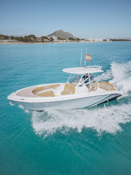 A speedboat on turquoise water with a mountainous landscape in the background. 1