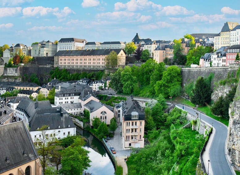 A historic town with a river, stone walls, and a mix of traditional and modern architecture. 5