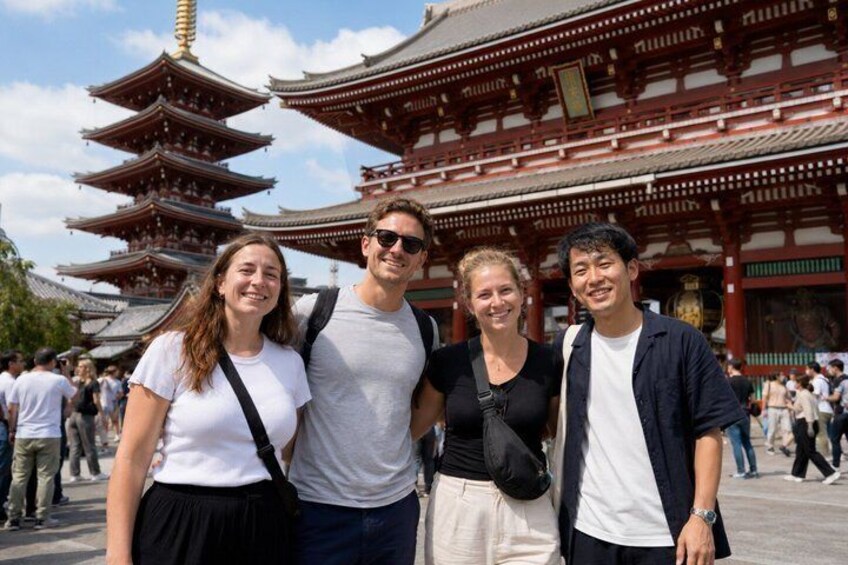 Un gruppo di persone davanti a una pagoda tradizionale giapponese con diversi livelli. 3