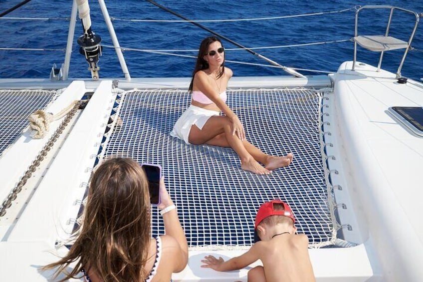 Una persona sul ponte di una barca, un'altra che scatta una foto e una terza persona sullo sfondo. 3