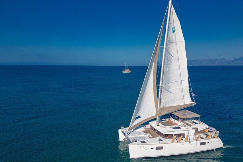 Una barca a vela bianca con cabina e una vela grande sull'acqua. 2