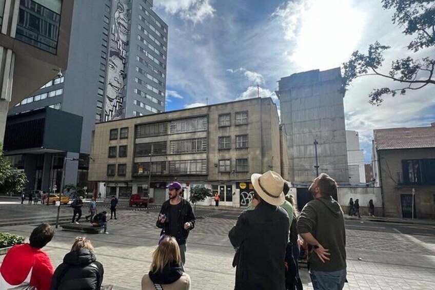 A group of people gathered in an urban square with modern buildings in the background. 4