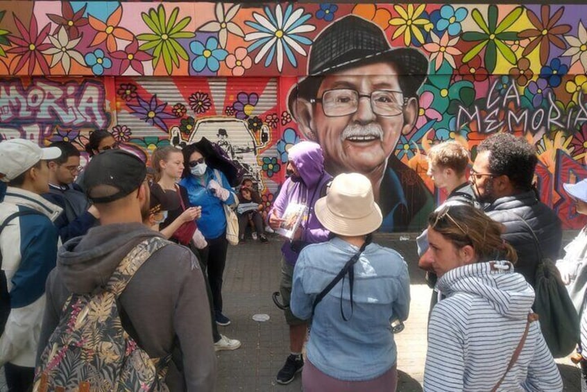 A mural with colorful flowers and a large portrait of a man. 3
