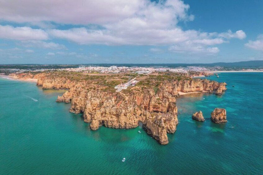 A coastal landscape with rocky formations and clear turquoise waters. 4