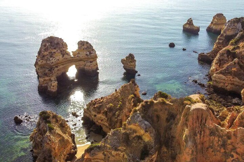 A coastal landscape with prominent rock formations and clear blue water. 1