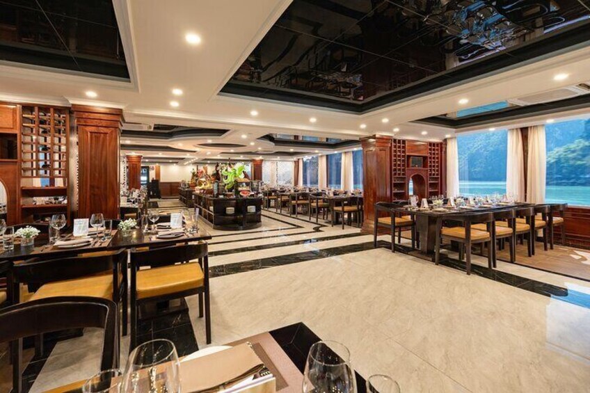 Een ruim restaurant met meerdere eettafels en stoelen, houten kasten en grote ramen. 3