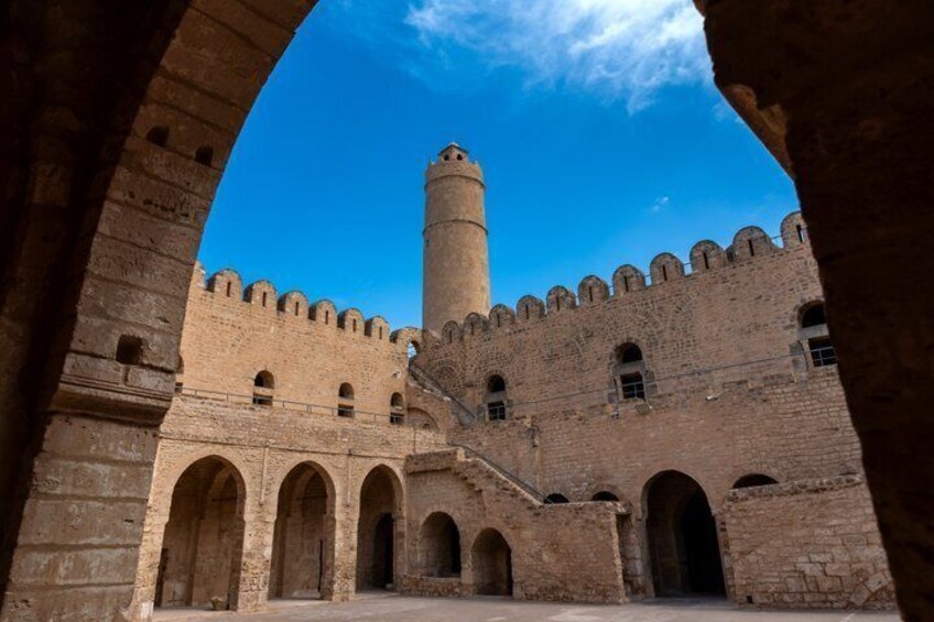 A historic fortress with a prominent tower and arched gateways. 3