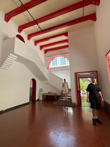 A spacious interior with red beams, a staircase, and a person standing. 4