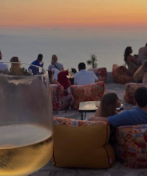 A sunset view with people seated on patterned outdoor furniture. 4