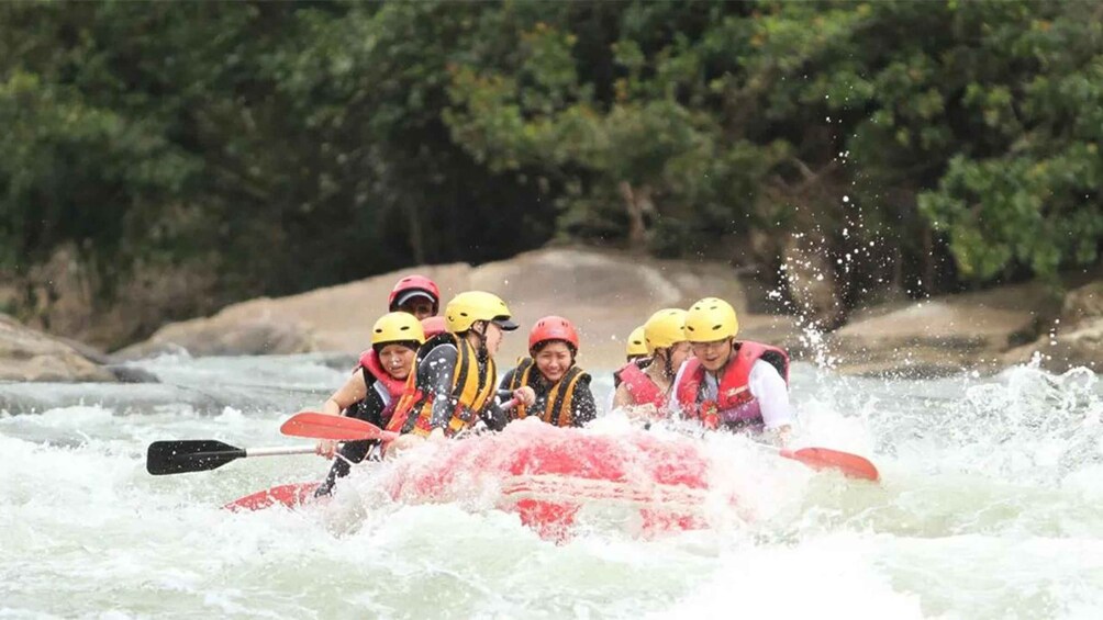 A group of people in a red raft navigating a river. 1
