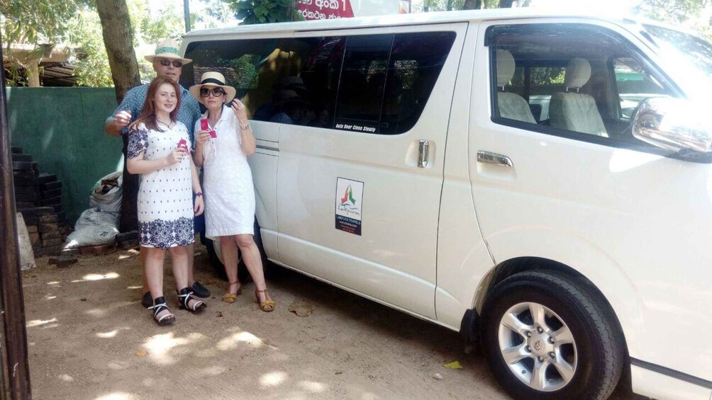 A white van parked outdoors with a logo on its side. 2
