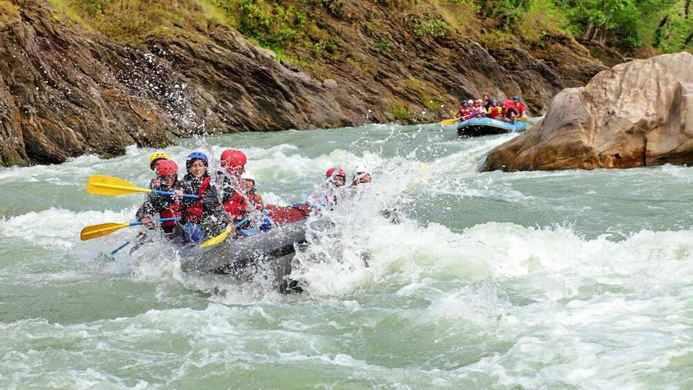 A group of people in a raft navigating a river with rapids. 4