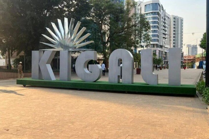 Une grande enseigne métallique sur laquelle on peut lire le mot « KIGOU », le tout étant placé sur une plateforme verte. 4