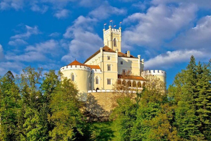 A castle with a tower, surrounded by trees and a clear sky. 2