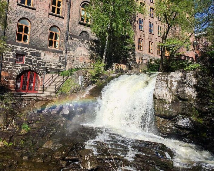 A waterfall cascading over rocks with a stone building in the background. 5