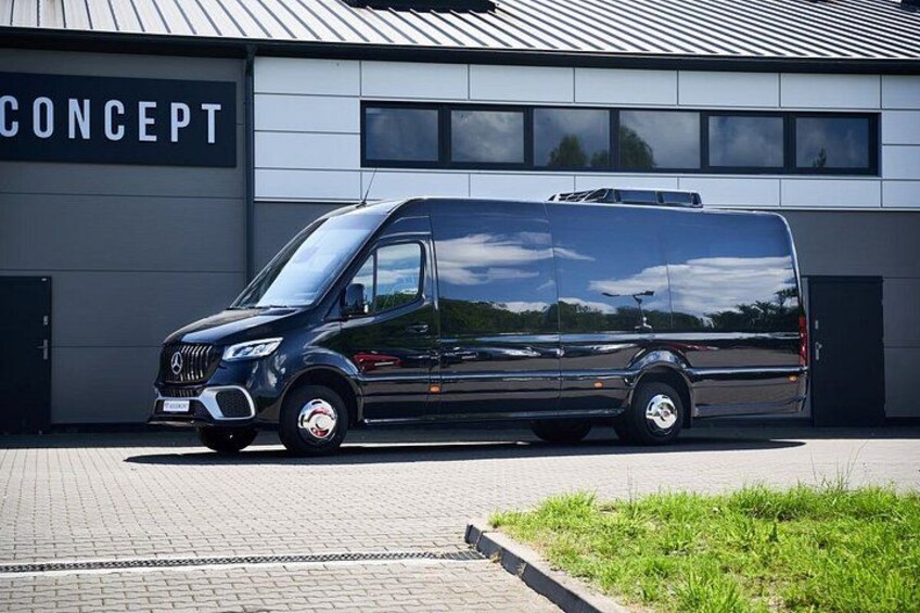 Een zwarte Mercedes-Benz Sprinter bestelwagen geparkeerd voor een gebouw met een bord waarop 'CONCEPT' staat. 2