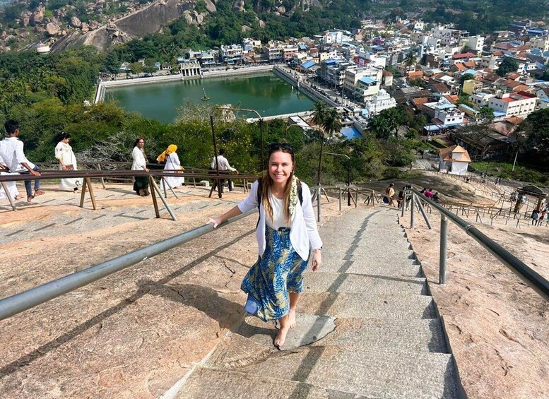 A person descending a stone staircase with a cityscape and a lake in the background. 1