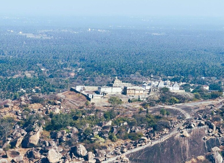 A temple complex surrounded by rocky terrain and dense forest. 4