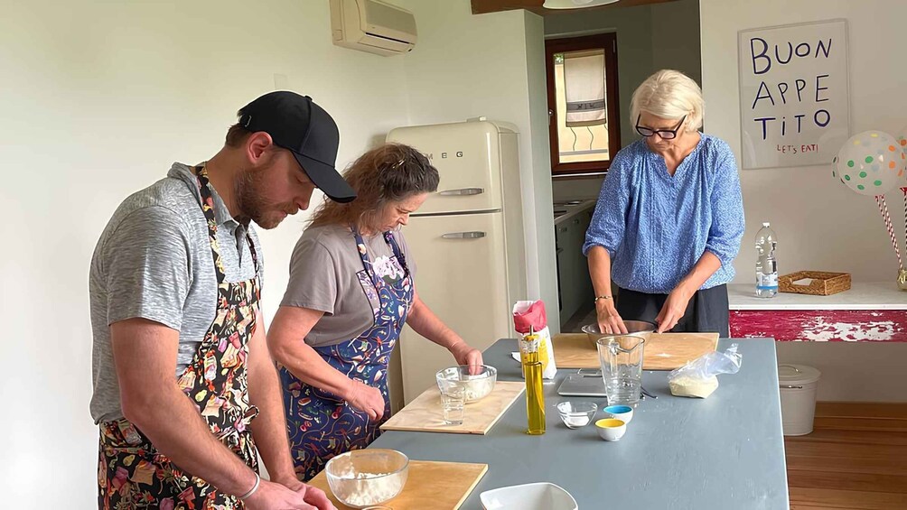 Three people cooking in a kitchen. 1