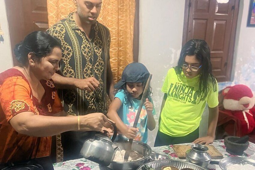 A family cooking together with pots and pans on a table. 3