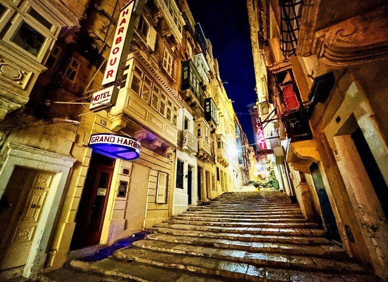 A nighttime street with a staircase leading up to a building labeled 'GRAND HARE.' 5