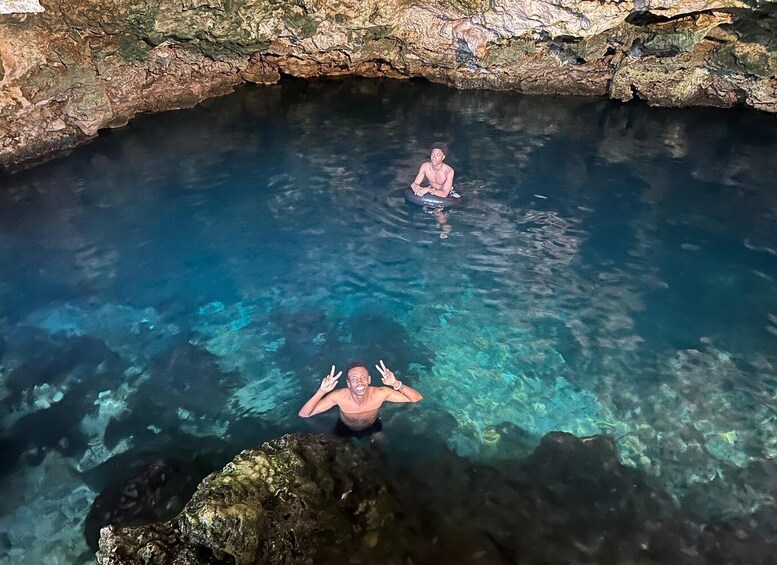 A person diving into a clear blue pool surrounded by rocky terrain. 5
