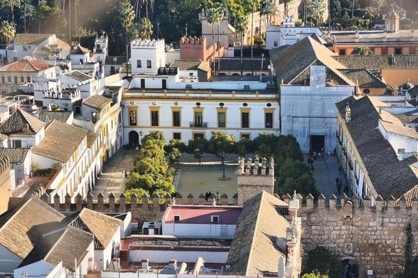 Ett historiskt torg med vita byggnader, en central innergård och en mur av sten. 1