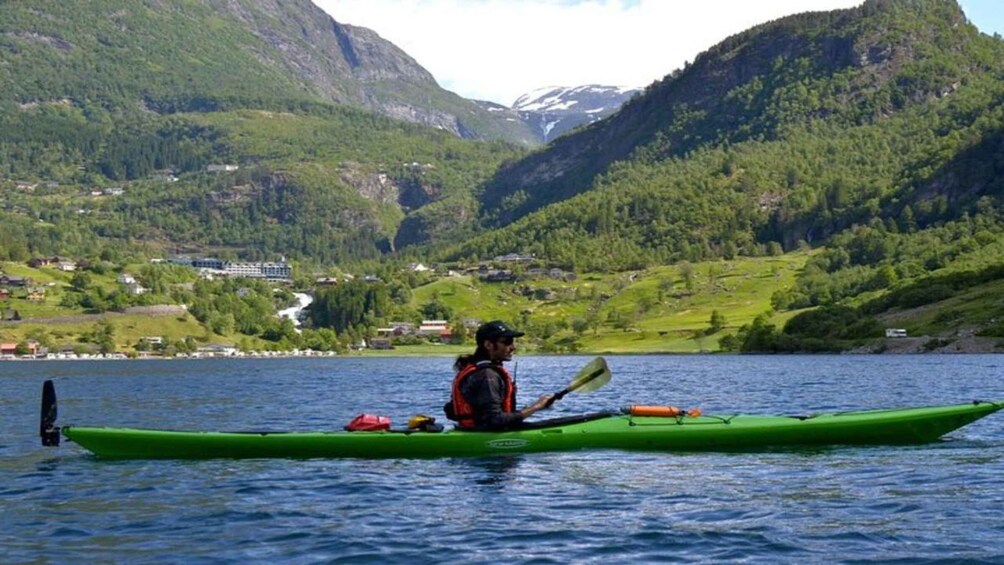A person kayaking on a lake surrounded by mountains. 1