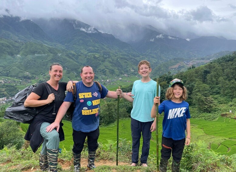 A group of people standing on a hill with a mountainous landscape in the background. 4