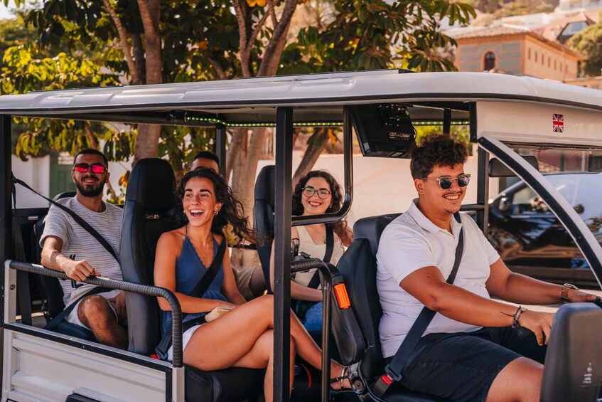 A golf cart with four passengers. 5